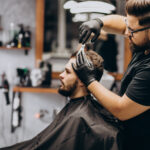 Client doing hair cut at a barber shop salon